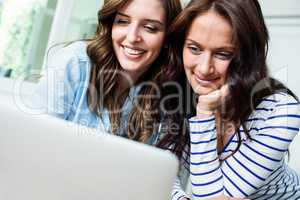 Happy female friends working on laptop