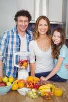 Portrait of happy family preparing fruit juice