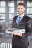 Young businessman with laptop and documents at office