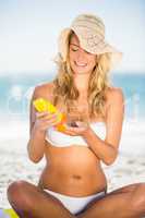 Smiling woman applying sunscreen