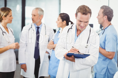 Male doctor writing on clipboard