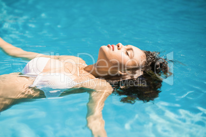 Beautiful woman floating in pool