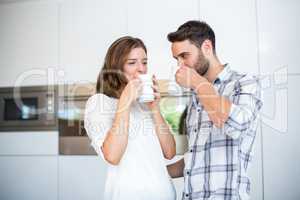 Couple drinking coffee in kitchen at home