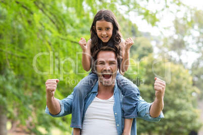 Father carrying her daughter on shoulder