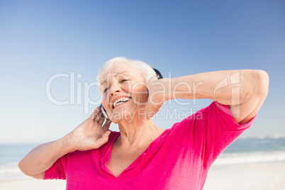 Senior woman listening music with headphone