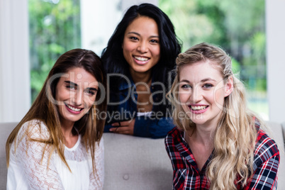 Happy beautiful young female friends in living room
