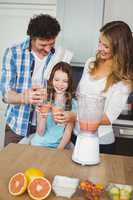 Smiling family toasting fruit juice