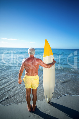 Senior man posing with a surfboard