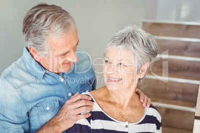 Cheerful senior couple looking at each other on staircase