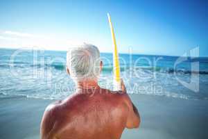 Senior man posing with a surfboard