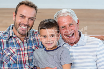 Father, son and grandson sitting on sofa