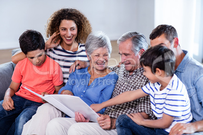 Happy family sitting on sofa and looking at photo album