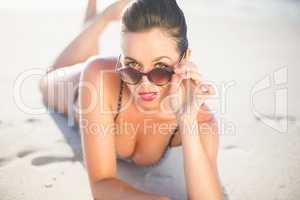 Glamorous woman in bikini lying on the beach