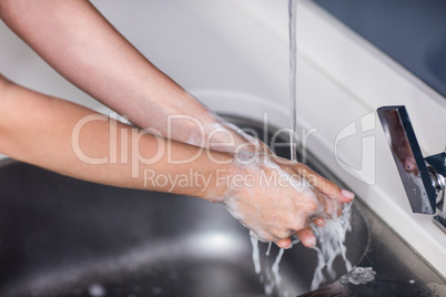 Cropped image of woman rinsing hands
