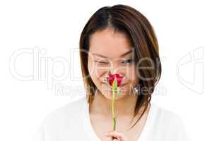 Happy young woman smelling rose