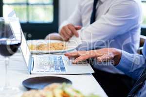 Close-up of man using laptop during a business lunch meeting
