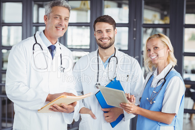 Portrait of smiling senior doctor with coworkers