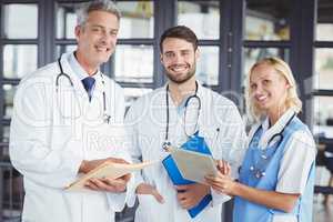 Portrait of smiling senior doctor with coworkers