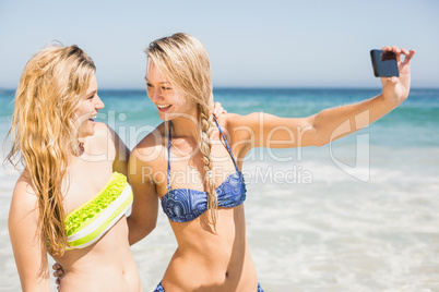 Two friends looking at each other while taking selfie