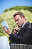 Thoughtful businessman using tablet