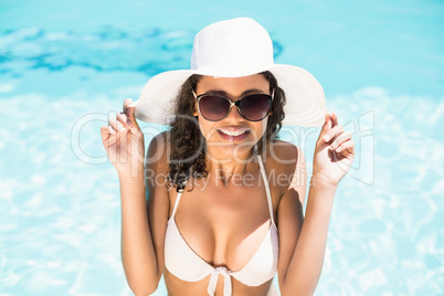 Happy woman in hat having fun by pool side