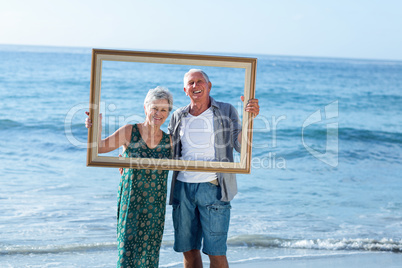 Senior couple posing with a frame