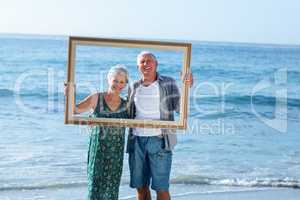 Senior couple posing with a frame