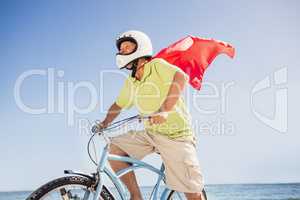 Senior superhero riding bike