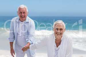 Senior couple playing at the beach