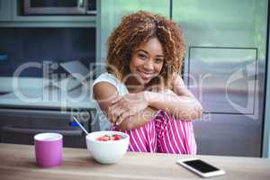 Happy woman sitting by table during breakfast
