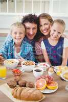 Portrait of family smiling while having breakfast