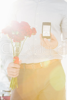 Happy young man holding engagement ring