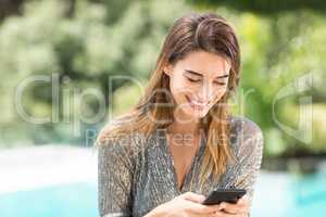 Woman smiling while using mobile phone