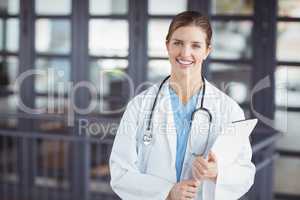 Portrait of confident female doctor holding clipboard