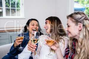 Cheerful female friends drinking wine