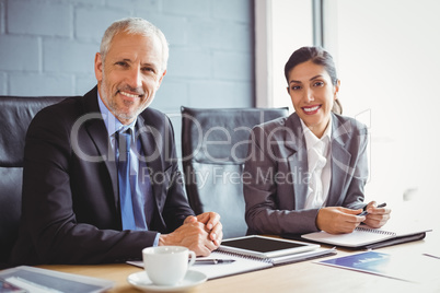 Businessman and businesswoman sitting in conference room