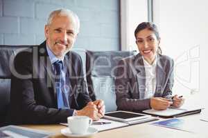 Businessman and businesswoman sitting in conference room