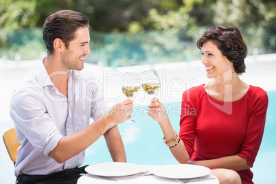 Smiling couple toasting white wine