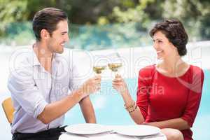 Smiling couple toasting white wine