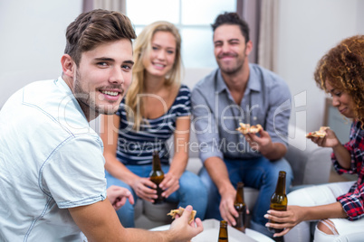 Young friends enjoying beer and pizza