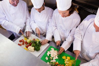 Team of chefs chopping vegetables