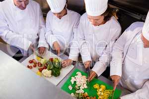 Team of chefs chopping vegetables