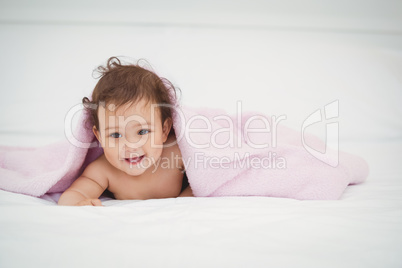 Cute smiling baby lying under blanket