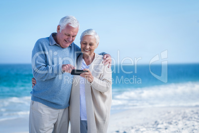 Cute mature couple looking at smartphone