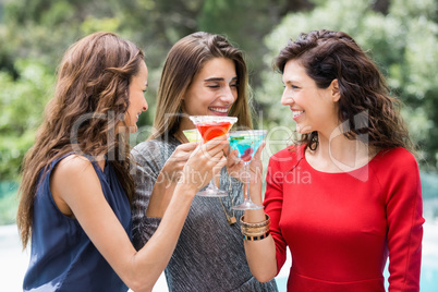 Attractive female friends drinking cocktail
