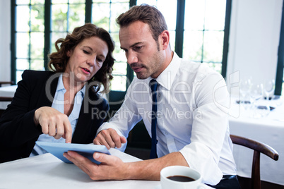 Business colleagues using a digital tablet while having a meetin