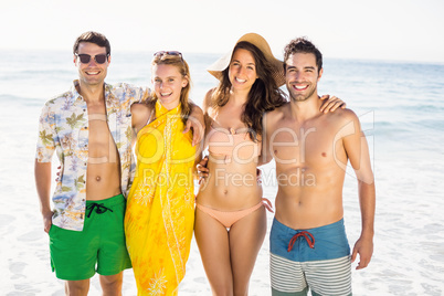 Portrait of happy friends standing together on the beach
