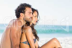 Happy couple sitting on the beach