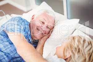 Happy senior couple lying on bed