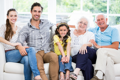 Portrait of smiling family with grandparents on sofa